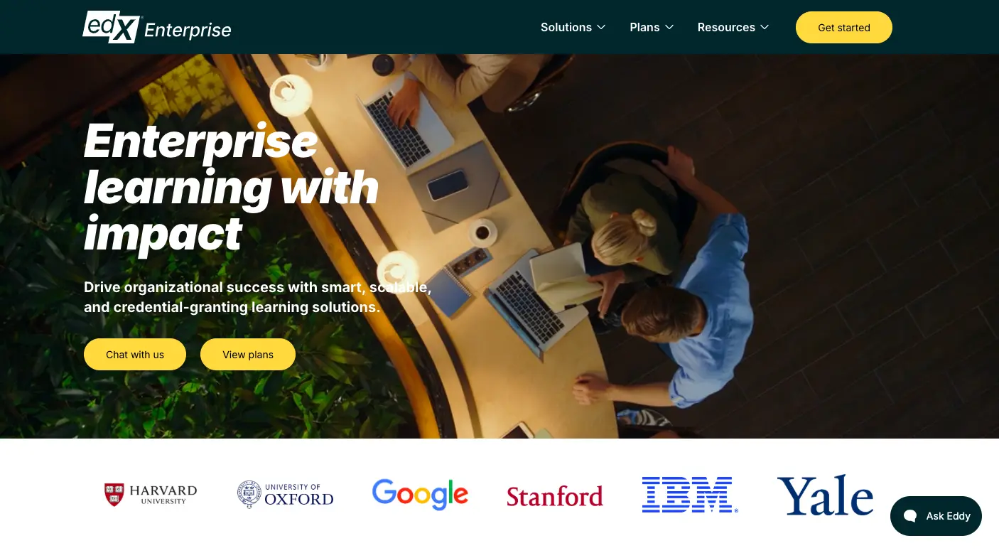 Enterprise learning platform by edX Enterprise showing professionals collaborating on laptops with branding from top institutions like Harvard, Oxford, Google, Stanford, IBM, and Yale